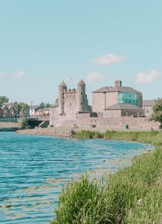 an old castle sits next to a body of water