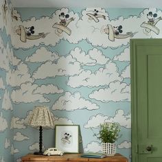 a room with mickey mouse wallpaper and green door