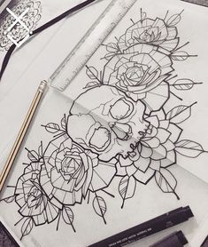 some flowers and pencils are on top of a piece of paper that has been drawn