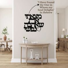 a room with a table and a clock on the wall that says, i have found the one in whom my soul delights in hebrew