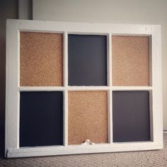 a white frame with several different colored corks in the middle and one black board behind it