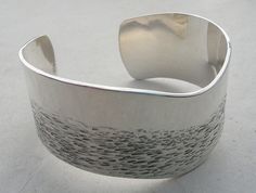 "Hand forged silver bangle by Carla Pennie. Silver bangle forged into sculptural form.  Surface of metal adds another dimension with repeated hammer marks on surface. One edge textured and oxidised the other remains flat and finished to brush finish.  Interior highly polished with makers mark.  Very ergonomic to wear. Beautiful casual or smart. Size 1\" x approx 6 1/4\" .  Opening 1 1/4\"  As silver is hand forged  the opening can be adjusted to fit any wrist size. Handmade in Santa Fe , New Mexico in studio of Carla Pennie McBride The jewelry is handmade, every piece will be unique and slightly different. I always send an image of the finished piece before I ship. Uniquely gift wrapped!" Contemporary Bracelets, Modern Silver Jewelry, Copper Cuff Bracelet, Designer Handmade Jewellery, Silver Jewelry Design, Copper Cuff, Jewelry Metal, Spiral Earrings, Mens Silver Rings