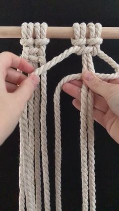 two hands are pulling up the ends of rope to make a wall hanging or door hanger