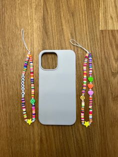 an iphone case with two colorful bracelets and a phone holder on a wooden table