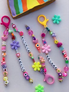 a table topped with lots of colorful bracelets and beads next to a slice of cake