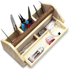 a wooden box with scissors and other tools in it