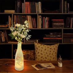 a vase filled with flowers sitting on top of a table next to a book shelf