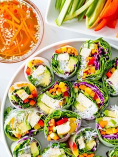 a white plate topped with lots of veggies next to sliced carrots and celery