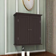 a bathroom with a wooden cabinet next to a wall hanging above the sink and mirror