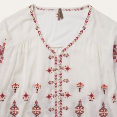 This top offers a soft and flowing silhouette with bohemian embroidered detailing throughout, including subtly hidden buttons at the front. A relaxed choice for brunch, a music festival, or wherever else the season takes you. 100% Viscose 3/4 Elastic Gathered Sleeves Curved Front and Straight Back Yokes Self-Covered Button Front Imported Bohemian V-neck Rayon Peasant Top, Summer Folk Style Blouse With Boho Print, Summer Folk Blouse With Boho Print, Summer Boho Print Folk Blouse, Bohemian V-neck Blouse With Embroidered Hem, Summer Embroidered V-neck Peasant Top, Bohemian V-neck Embroidered Top, Spring Festival V-neck Peasant Top, Spring Folk Blouse With Boho Print