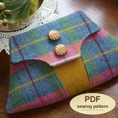 a colorful plaid purse sitting on top of a table next to a potted plant