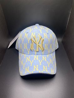 a new york yankees baseball cap with yellow letters on it and a knife sticking out of the visor