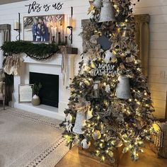 a decorated christmas tree in a living room next to a fireplace with candles and pictures on the mantle