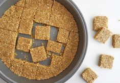 a pan filled with crackers next to some cut up squares on top of it