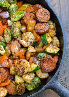 a skillet filled with cooked vegetables on top of a wooden table