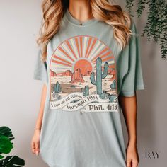 Introducing our Boho Christian Tee "I can do all things through HIM" Phillippians 4:13, featuring a beautiful desert scene at sunset, or sunrise! Comes in multiple colors#bohemian #bible #christianity #desertlife #bohostyle #bohochic #comfortcolorstee #oversizedshirt #inspirationaltees #churchoutfit #bibleverse Boho Christian, Bible Verse Shirt, Distressed Tee, Christian Tees, Christian Shirt, Fashion Graphic, Comfort Colors Tee, Christian Clothing, Christian Shirts