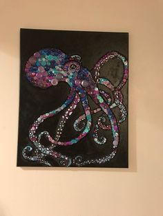 an octopus made out of buttons is hanging on the wall