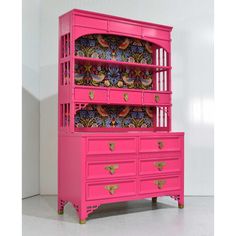 a pink dresser with many drawers on it