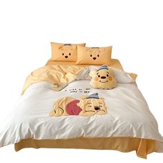 a bed with winnie the pooh comforter and two pillows