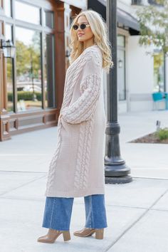 Wrap yourself in cozy comfort with our Chunky Cable Knit Duster Cardigan in a soft light beige hue! Designed for the free-spirited and effortlessly chic, this longline cardigan is the perfect layering piece for any boho-inspired look. Crafted from a chunky cabe knit material, this duster cardigan offers maximum coziness, giving you that wrapped-in-a-blanket feel with a stylish twist. Perfect for layering during those crisp fall mornings or cool evenings, this cardigan is an essential for any boh Long Beige Sweater For Winter, Long Beige Winter Sweater, Winter Beige Soft Knit Sweater Coat, Long Cream Cardigan For Winter, Beige Knitted Sweater Coat For Fall, Knitted Beige Sweater Coat For Fall, Beige Long Knit Outerwear, Trendy Cream Soft Knit Outerwear, Long Beige Knit Outerwear