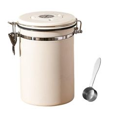 a white canister with a spoon on the side