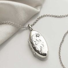 "This sterling silver oval locket, makes a wonderful keepsake, and memorable gift.  The front features a beautiful floral design and the back is blank, ideal for engraving a name, date or short message. The perfect sentimental gift for a friend or loved one. So why not make this a truly personal gift by having your own special message engraved, by us, on this eye catching locket. To order this locket simply select the chain length and the font you would like us to use from the drop down menus, you can select \"no engraving\" if you would like us to leave it blank. Then at the checkout enter the message you would like us to engrave in the \"note to seller\" box. Ideally 30 characters fits best on this locket. Both the locket and the chain are made from sterling silver. The locket measures 3 Oval White Gold Locket Necklace For Keepsake, White Gold Oval Locket Necklace For Keepsake, Oval White Gold Locket Necklace Keepsake, Silver Oval Link Locket Necklace Keepsake, Silver Oval Locket Necklace For Keepsake, Oval Pendant Locket Necklace With Engraving Option, Engraved Oval Pendant Locket Necklace, Silver Oval Locket Necklace Keepsake, Silver Oval Locket Necklace With Engraving Option