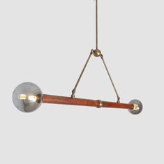 a wooden and metal light fixture hanging from the ceiling with two lights on each side