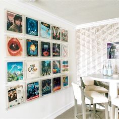 there is a white table and chairs in the room with many pictures on the wall