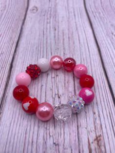 Bubblegum bead bracelet . Mix of 12mm bubble gum beads. Pattern varies with each order. Pink, white, red bubblegum beads,  heart charm.  Disclaimer-contains  small parts. Choking hazard. Not for children under 3. Adjustable Red Stretch Bracelet For Birthday, Pink Beaded Bracelets For Birthday, Pink Round Beads Bracelets For Birthday, Heart Bracelet With Round Beads For Valentine's Day, Playful Red Stretch Bracelet For Gift, Hypoallergenic Heart-shaped Beaded Bracelets For Valentine's Day, Playful Red Beaded Bracelets, Valentine's Day Playful Beaded Jewelry, Cute Heart Beads Beaded Bracelets For Valentine's Day