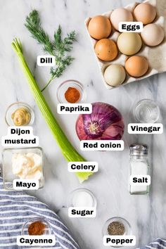 the ingredients to make an egg salad on a marble counter top with eggs, onions, dill, mayonnaise and other ingredients