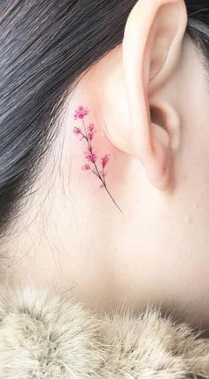 a small pink flower behind the ear