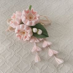 a close up of a flower on a table cloth with leaves and flowers attached to it