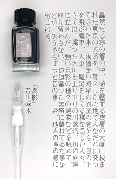 an ink bottle and some writing on a white surface with chinese characters written in it