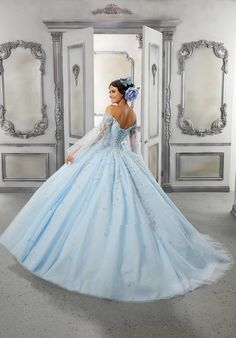 Have an unforgettable day in this stunning Quincenaera gown from Valencia by Morilee. This gown, 60143, is an angelic quinceanera ball gown featuring lovely crystal beaded, three-dimensional floral appliques with beaded lace cascading down from the off-the-shoulder bodice to the full tulle over sparkle tulle skirt. Ethereal, detachable angel sleeves finish off the dress. Matching stole included. Quinceañera Dresses, Off Shoulder Ball Gown, Blue Ball Gown, Angel Sleeves Dress, Cross Dresser, Full Tulle Skirt, Quince Dress, Princess Sleeves, Angel Sleeves