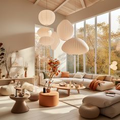 a living room filled with lots of furniture and large windows covered in white paper lanterns