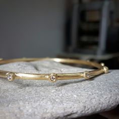 Handcrafted in solid 18k gold, the raw organic texture of this beautiful diamond bangle is contrasted by the brilliant sparkle of white diamonds.  The amorphic little globules are each set with a white 2 point vvs diamond. This diamond bracelet is beautiful by itself, and can also be worn with other bangles in a stack. This bracelet can be ordered without the diamonds, as seen in the last two pictures. Ask me for a quote. Dimensions: > The thickness of the bracelet is about 3 mm  > The inside di Yellow Gold Bracelet With Single Cut Diamonds For Anniversary, Anniversary Bracelet With Single Cut Diamonds In Yellow Gold, Heirloom Yellow Gold Bracelet With Diamond Accents, Hand Forged Elegant Bangle, Yellow Gold Bangle With Single Cut Diamonds For Gift, Anniversary Jewelry Bracelet With Single Cut Diamonds, Heirloom Yellow Gold Round Diamond Bracelet, Gold Bangle With Single Cut Diamonds As Gift, 14k Gold Bangle With Diamond Accents As Gift