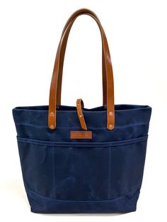 The Virginia Beach Tote with Navy waxed canvas and Navy leather. Our everyday beach tote. Organization forward with six interior and six exterior pockets. From a beach goer to a jetsetter, we have you covered.    **All Navy Bag sales are final! No returns, refunds, or exchanges** Please allow all on-line orders 7-10 b Navy Bag, Tote Organization, Natural Tan, Navy Leather, Waxed Canvas, Beach Tote, Virginia Beach, Bag Sale, Virginia