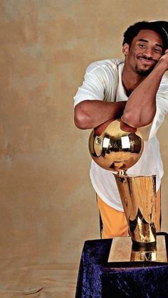 a man holding a golden trophy on top of a table