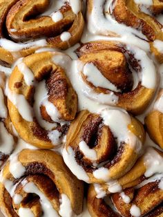 many cinnamon rolls with icing on top of each one