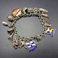 "VINTAGE WORLD TRAVEL CHARM BRACELET DESCRIPTION: This exquisite collectible features an abundance of sterling silver charms, some very interesting and rare additions. BOOMERANG SS ORSOVA FLAG (from the Orient Steam Navigation Company 1954-66 and Peninsular and Oriental Steam Navigation Company 1966-74 KANGAROO ABORIGINAL INDIGENOUS AUSTRALIAN HUNTER EIFFEL TOWER WOK with CHOPSTICKS PINEAPPLE from HAWAII (not sterling) CHINESE KONGMING LANTERN THEATRE MASK (Sock and Buskin Comedy/Tragedy) REDLIN Vintage Jewelry With Dangling Charms Souvenir, Vintage Jewelry With Dangling Charms As Souvenir, Vintage Dangling Charms Jewelry Souvenir, Collectible Sterling Silver Antique Bracelet, Collectible Symbolic Charm Jewelry, Antique Jewelry With Dangling Charms For Collectors, Antique Souvenir Jewelry With Charms, Silver Symbolic Jewelry Souvenir, Antique Hallmarked Charm Bracelet As Gift