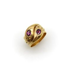 This is part of Chairish’s Fine Jewelry assortment.  This is a classic 9k gold snake ring that has two beautiful rhodolite garnets in the head of each snake. The snake heads interlock   and the garnets are bead set into a mount that are carved to look like tulips. The oval rhodolite garnets are a deep purple pink and have a beautiful fire to their rich, reddish purple hue. The snakes have a cute mouth detail—almost like a smile—and their tails appear on each side of the ring. The wide ring band Pomegranate Ring, Historical Rings, Snake Heads, Persian Jewelry, Reddish Purple, Serpent Ring, Rhaenyra Targaryen, Wide Ring, Bead Set