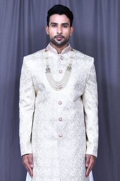 Light beige jacquard sherwani with floral and thread embroidery. Comes with white banglori silk churidar and anarkali kurta.
Components: 3
Pattern: Embroidered
Type Of Work: Floral, Thread
Neckline: Mandarin collar
Sleeve Type: Full
Fabric: Banglori silk, Sherwani: Jacquard
Color: Beige
Other Details: 
Closure: Sherwani - Front buttons
Note: Mala worn by the model is not for sale.
Occasion: Wedding,Groom - Aza Fashions Silk Churidar, Embroidered Sherwani, Jayanti Reddy, Anarkali Kurta, Tarun Tahiliani, Luxury Sale, Thread Embroidery, Churidar, Modern Bride