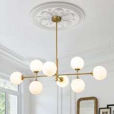 a chandelier hanging from the ceiling in a room with white walls and windows