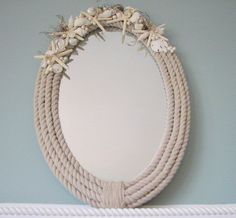 a rope wreath hanging on the wall next to a mirror