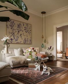 a living room filled with furniture and a dog laying on top of a rug in front of a painting