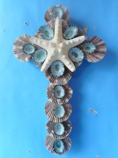 a cross made out of seashells on a blue background