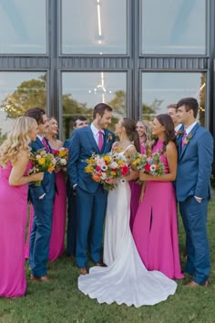 a group of people standing next to each other in front of a building with windows