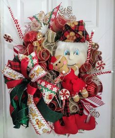 a christmas wreath with a teddy bear and candy canes on the front door handle