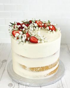 a white cake with strawberries and flowers on top