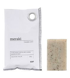 a bar of soap sitting next to a bag of soap on a white background with the label meraki